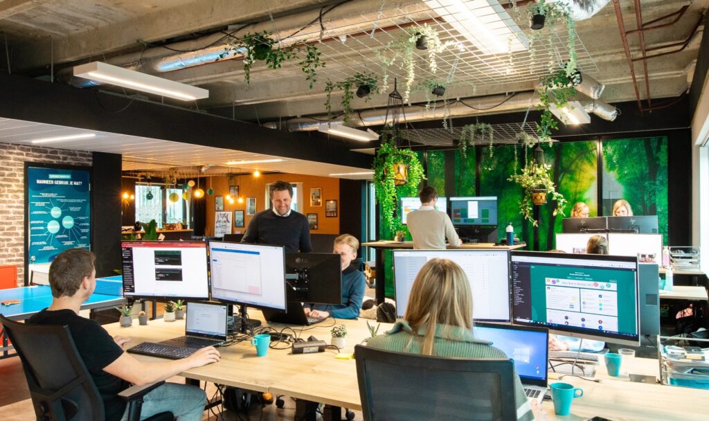 Team werkt samen achter meerdere schermen op kantoor