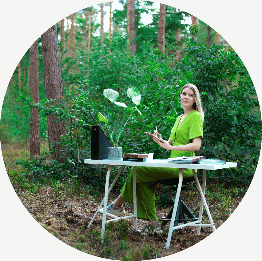 Leonie grafisch vormgever bij Rebelation en Positie1 aan het werk in een groene buitenomgeving