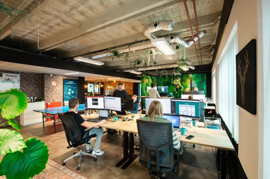 Team werkt samen achter meerdere schermen op kantoor