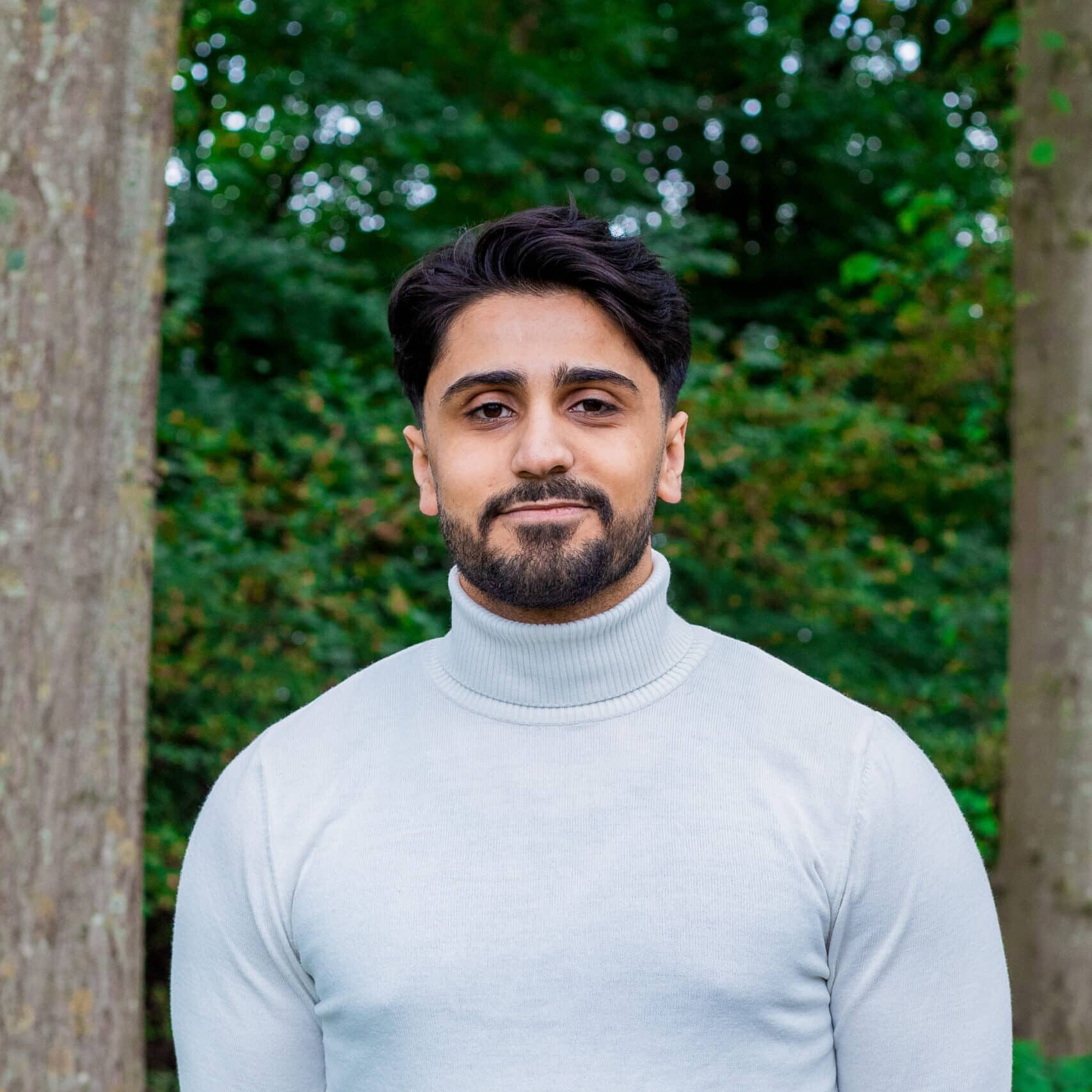 Abdulrahman online marketeer bij Positie1 staand buiten in groene omgeving