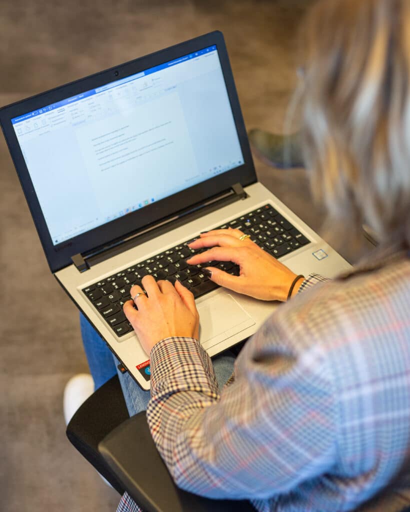 Chantal, contentspecialist bij Positie1, typt op haar laptop en werkt aan content