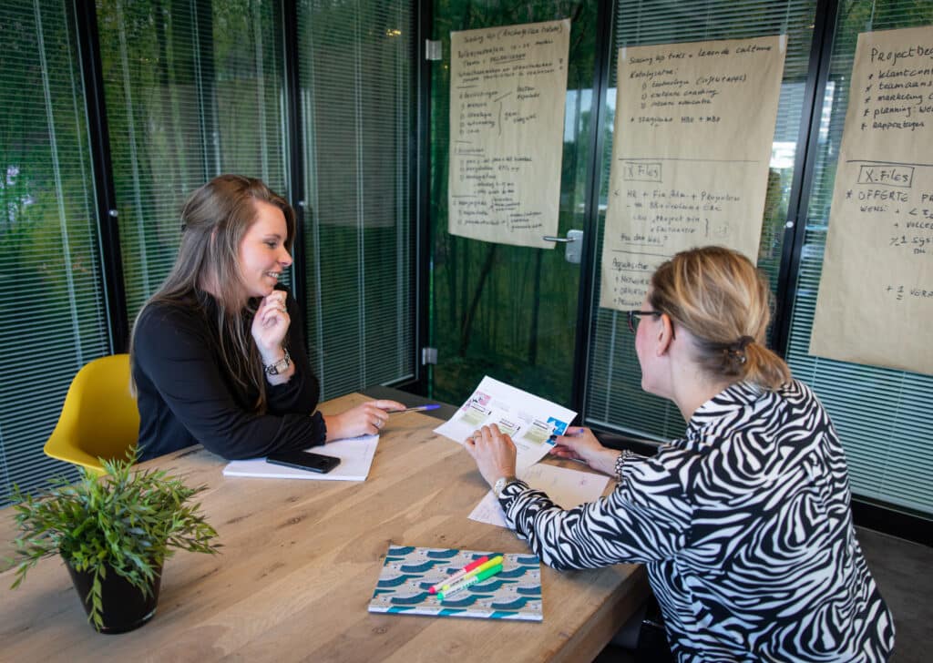 Ilona (online marketeer) en Chantal (contentspecialist) van Positie1, online marketing bureau, bespreken samen content aan tafel