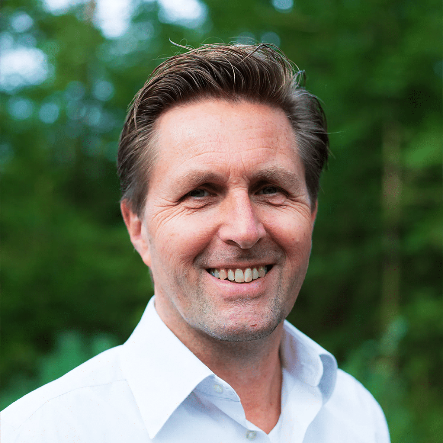 Eric oprichter van Positie1 lachend portret in groene buitenomgeving