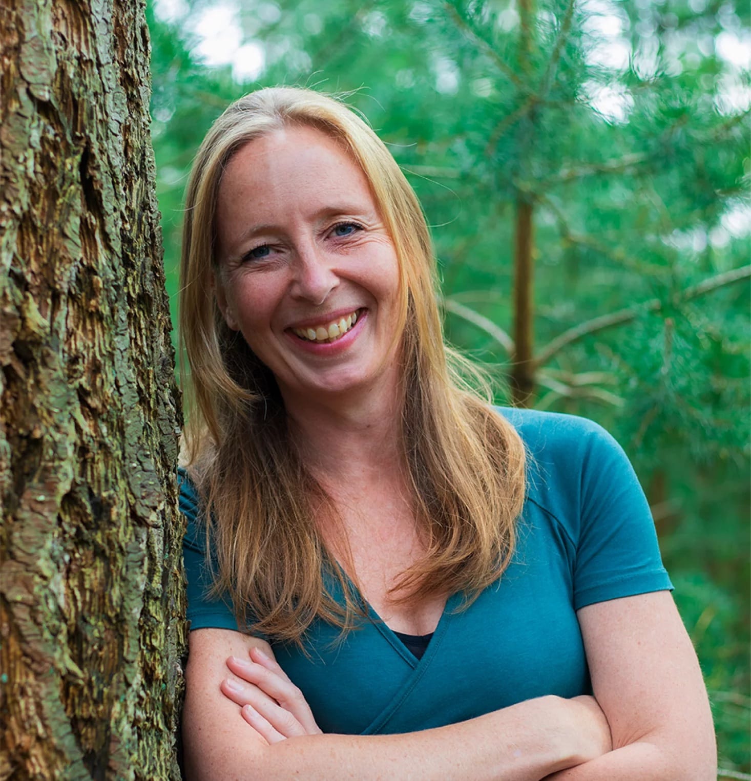 Heleen mede-eigenaar van Positie1 lachend portret in bosrijke omgeving bij boom
